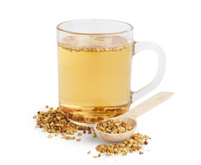 Glass cup of fresh buckwheat tea and wooden spoon on white background