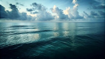 A serene ocean scene under a dark sky, featuring a bright sun and calm weather with scattered clouds.
