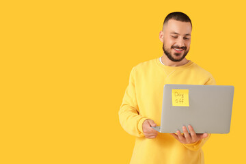 Young man with laptop on yellow background. Day off concept