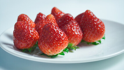 Red organic strawberries displayed on a white plate