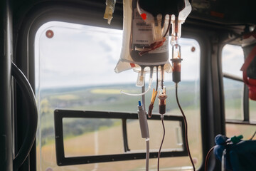 Transfusion bag with blood on board helicopter of air ambulance during flight. Themes emergency...