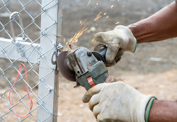The technician is using construction tools to grind the steel to make the surface smooth and free of roughness.