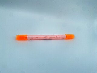A bright orange pen with a transparent body and streamlined pattern, radiating vibrant stationery aesthetics.