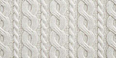A close-up of a soft, white knitted fabric with a classic cable knit pattern, showcasing the intricate texture and woven loops that create a cozy and inviting look.