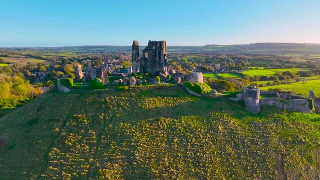 Aerial sunset view of Corfe Castle, a village and civil parish in the English county of Dorset, UK