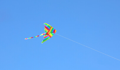 rainbow-colored kite flying high in the sky symbolizing freedom and carefreeness
