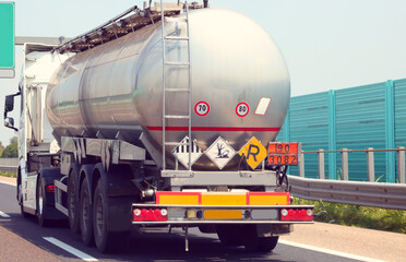fuel tanker speeding along highway noise barriers with hazardous material r sign