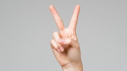 Peace Symbol Gesture with Hand Showing Victory Sign Against Neutral Background for Positive Vibes, Calmness, and Good Energy Representation