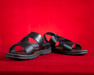 pair of black leisure sandal on red background
