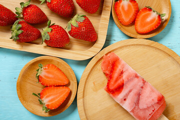 top view strawberry slices popsicle with couple of bites with fresh strawberries horizontal composition