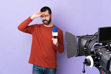 Reporter man holding a microphone and reporting news over isolated purple background with tired and sick expression