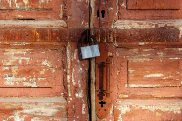 Old traditional wooden door with metal lock close-up. Metal lock for security. Lock on the door