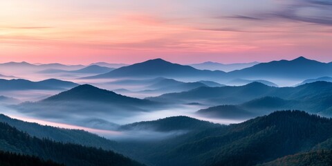 Fototapeta premium Breathtaking mountain landscape at sunset, featuring layered peaks and soft mist, creating a tranquil and serene atmosphere.