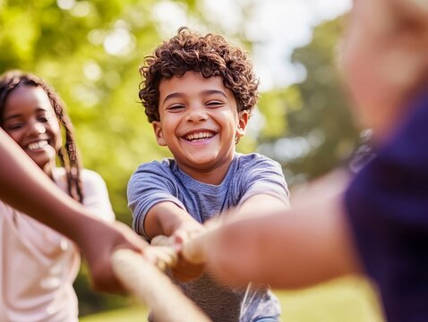 Joyful children engaged in tug of war at the park on a bright sunny day, close up portrait focus