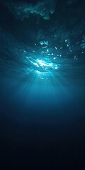Obraz premium Dark blue ocean surface seen from underwater with sunlight filtering through, creating a mesmerizing shimmering effect, sunlight, marine life, effect
