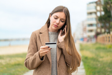 Young pretty blonde woman buying with the mobile with a credit card