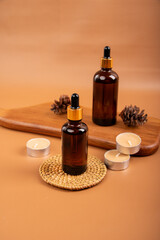 Amber Glass Dropper Bottles with Pinecones and Candle on Wooden Tray for Spa and Aromatherapy Decor