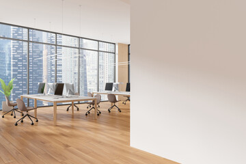 Spacious modern office interior with computers on desks and a large blank wall. Wooden floor, cityscape background. Concept of workspace design. 3D Rendering