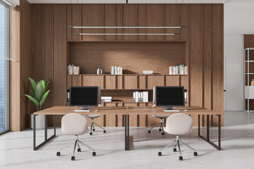 Wooden coworking interior with tables and pc desktop, panoramic window