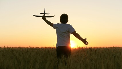 boy teenager child kid runs through field with wheat with toy plane his hands sunset, happy dream family, nature, dream astronaut sky, child dreams becoming pilot, kid run toy game by plane across © TO LOVE