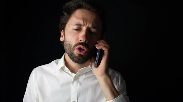 Young caucasian man is irritated while talking on the phone