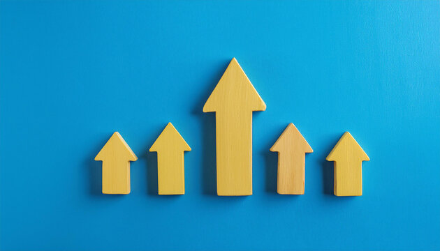 Yellow wooden arrow on blue background. Business and market growth concept.
