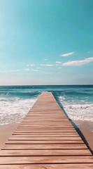 Fototapeta premium A wooden pier extends into the blue ocean on a sunny day. The waves gently lap against the shore, creating a peaceful atmosphere