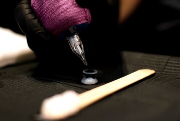 Close-up of Tattoo Machine Dipping into Ink Cap - Professional Tattoo Studio Equipment