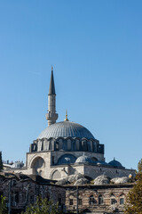 The dome of Istanbul's Rustem Pasha Mosque, blue and green tiled Ottoman architecture dominates the skyline.The slender minaret topped with a crescent moon adds to the elegant silhouette of the mosque