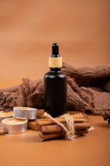 Naklejka premium Amber Glass Bottles with Cinnamon and Tealight Candles for Aromatherapy and Spa Decor