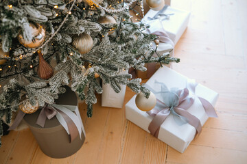 Decorated Christmas tree with presents under it in a cozy living room