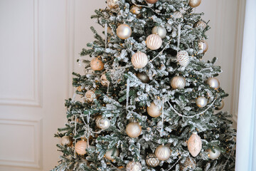 Decorated Christmas tree with silver and gold ornaments in a cozy room