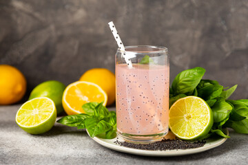 Diet detox cocktail with basil and chia seeds in a glass jar and a glass on a textured background....