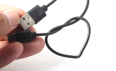 Hand holding USB cable, showing both ends on white background.