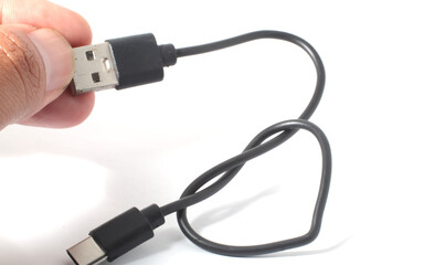 Hand holding USB cable, with connectors in focus on white background.