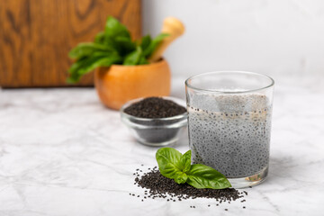 Basil seeds on textured wooden background. Close-up. Superfood. Ocimum basilicum. Organic basil seeds. selasih. Space for text. Copy space.