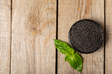 Basil seeds on textured wooden background. Close-up. Superfood. Ocimum basilicum. Organic basil seeds. selasih. Space for text. Copy space.