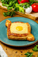 Georgian khachapuri with cheese and egg, beautifully served in a cafe, restaurant, rustic.