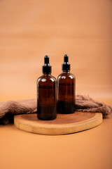 Amber Dropper Bottle with Cinnamon Sticks and Pinecones on Wooden Tray for Aromatherapy and Skincare