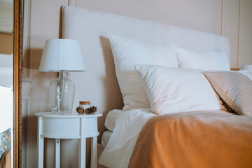 Cozy bedroom setting with a plush headboard and soft pillows beside a lamp