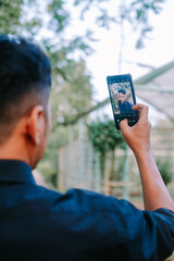 Southeast Asian man taking a selfie with a smile, capturing a casual moment