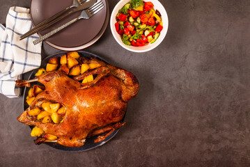 Crispy whole roasted duck on plate with potato and onion. Thanksgiving or Christmas dinner.