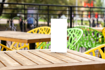 Blank brochure on the table in restaurants summer terrace in the city. Booklet with copy space. Mock up, Space for text