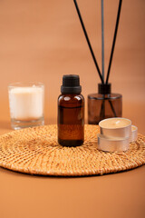 Amber Glass Essential Oil Bottle with Candles and Diffuser on Woven Mat for Spa and Relaxation