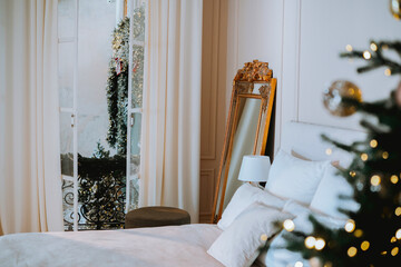 Cozy bedroom decorated for the holidays with a view of a balcony garden