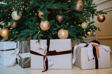 Festively wrapped presents beneath an elegantly decorated Christmas tree