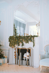 Elegant winter fireplace decorated with greenery in a cozy living room