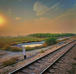 railway in the countryside,railway in the evening,railway track,sun set,beatiful view from train