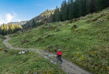 woman riding her electric mountain bike in the Bregenz Forest mountains near Hittisau, Vorarlberg Austria