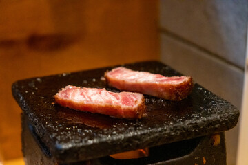 Gyukatsu or beef cutlet on the stone grill. It is traditional Japanese food that consists of a deep-fried beef cutlet.